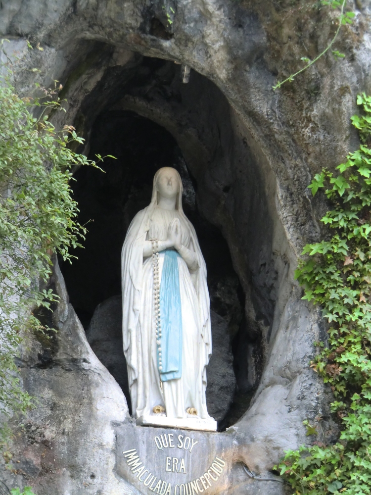 Die Marienstatue des Künstlers Fabisch, 1864, in der Grotte mit den Worten der Botschaft (im Dialekt): „Que soy era Immaculada Conceptiou”, „Ich bin die Unbefleckte Empfängnis”