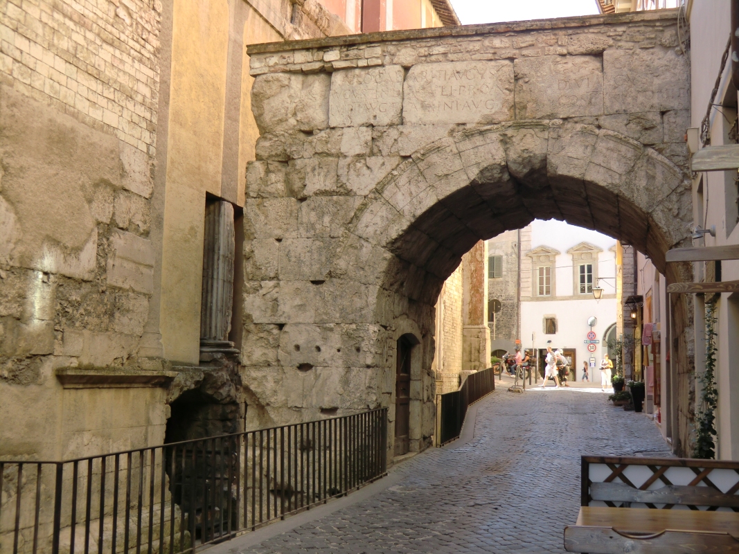 Reste des römischen Tempels in der Mauer der Kirche San Ansano (links) und römischer Torbogen in Spoleto